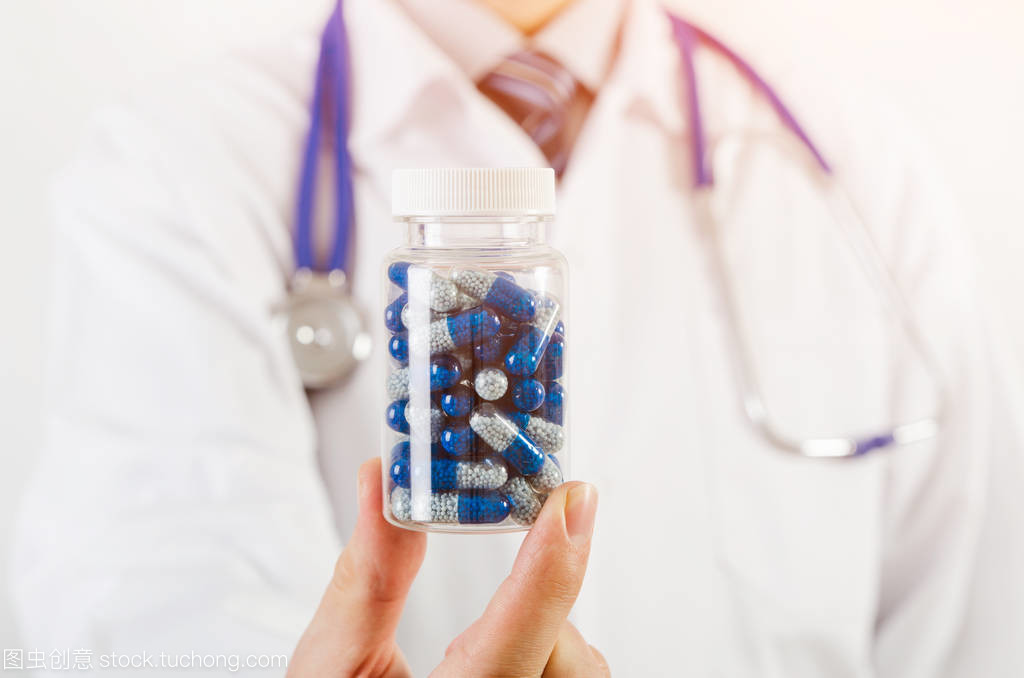 醫生科學家發明新的藥物,持有膠囊在手中